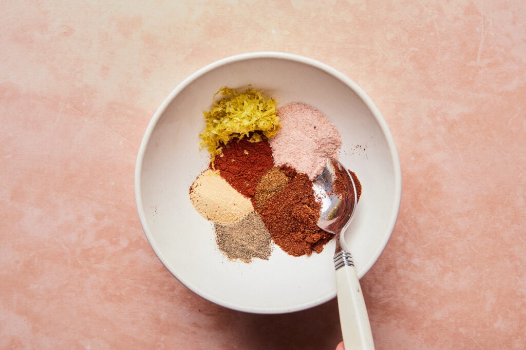 Mixing dry rub ingredients in a bowl.