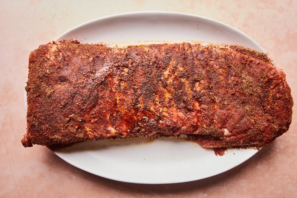 Pork ribs on a plate covered in chili lime dry rub.