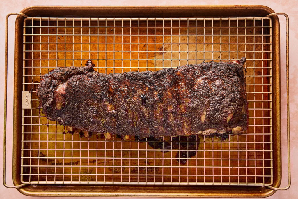 Ribs oven baked on a baking sheet with crispy brown crust.