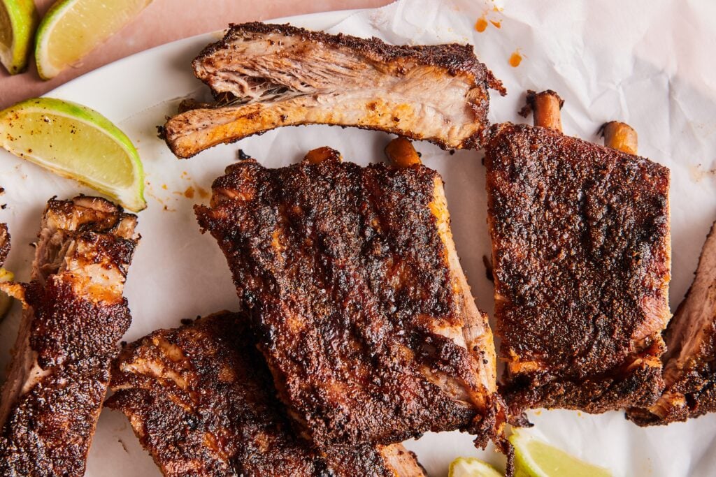 Chili lime ribs separated into sections and served with lime wedges.