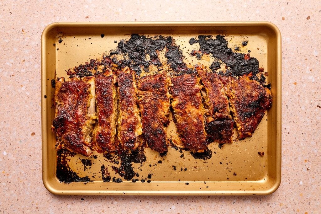 Pork ribs on a baking sheet broiled with Korean bbq sauce.