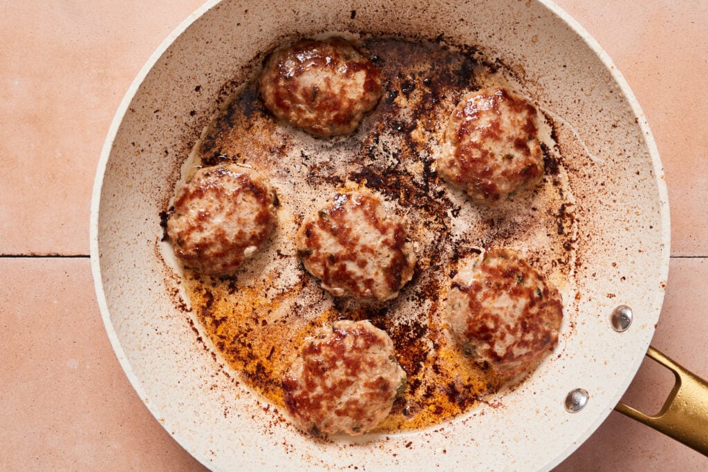 Pork sausage patties pan fried in a skillet