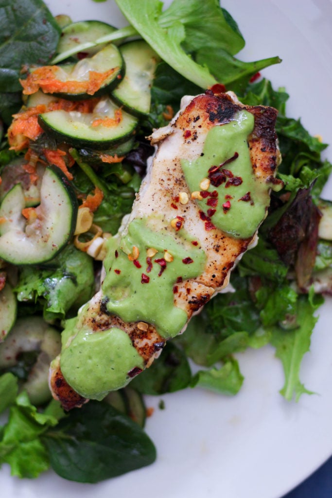 swordfish steaks covered in lemon basil sauce on top of lettuce and fresh veggies