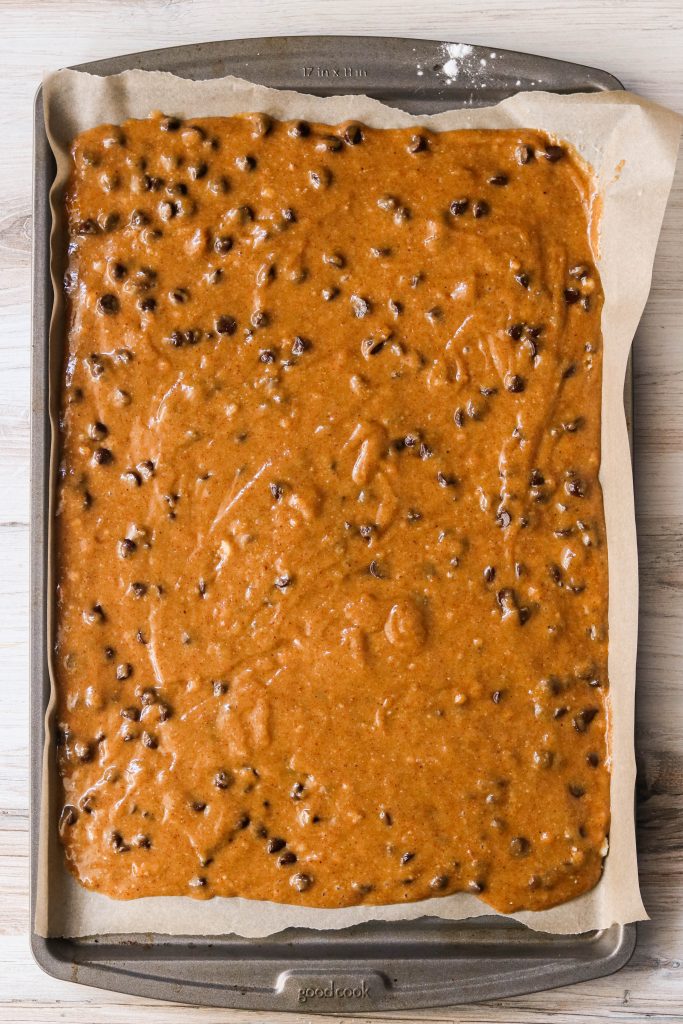 Batter for blondies with chocolate chips, spread on a sheet pan