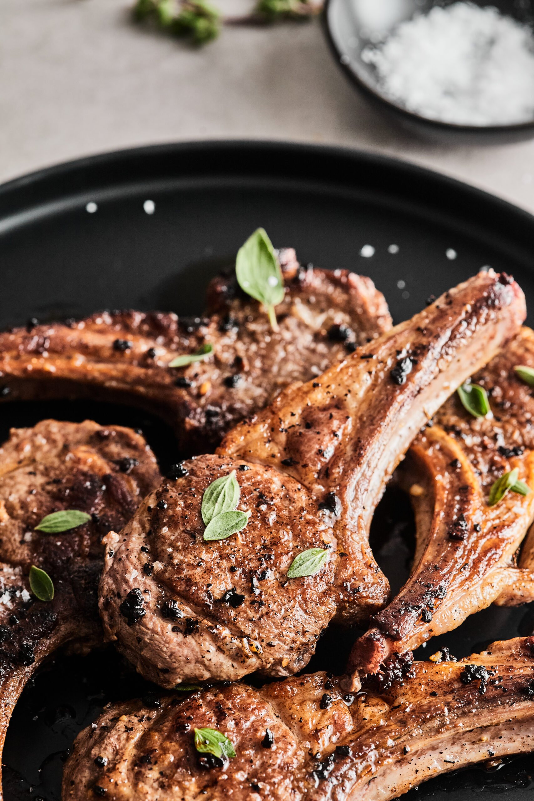 pan fried lamb chops on a black plate