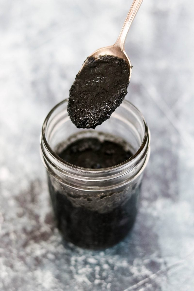 a jar of black sesame paste with a spoonful above the jar