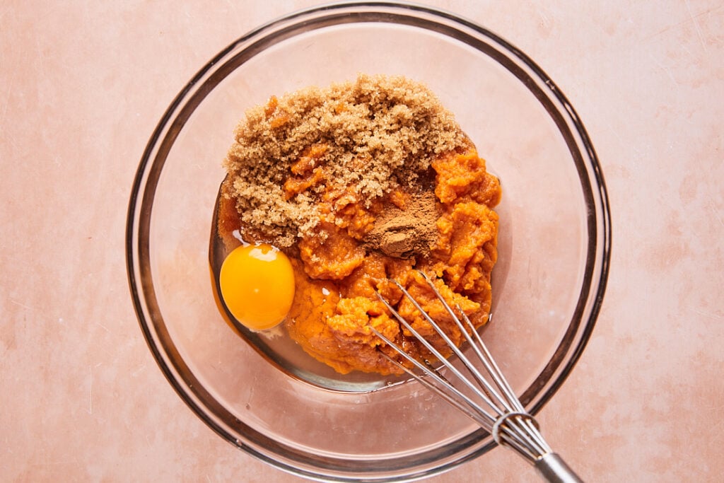 Whisking together pumpkin pie layer ingredients in a large bowl