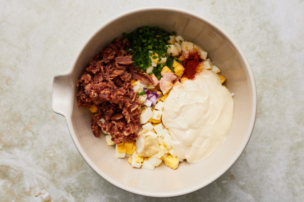 All the egg salad ingredients combined in a large bowl.