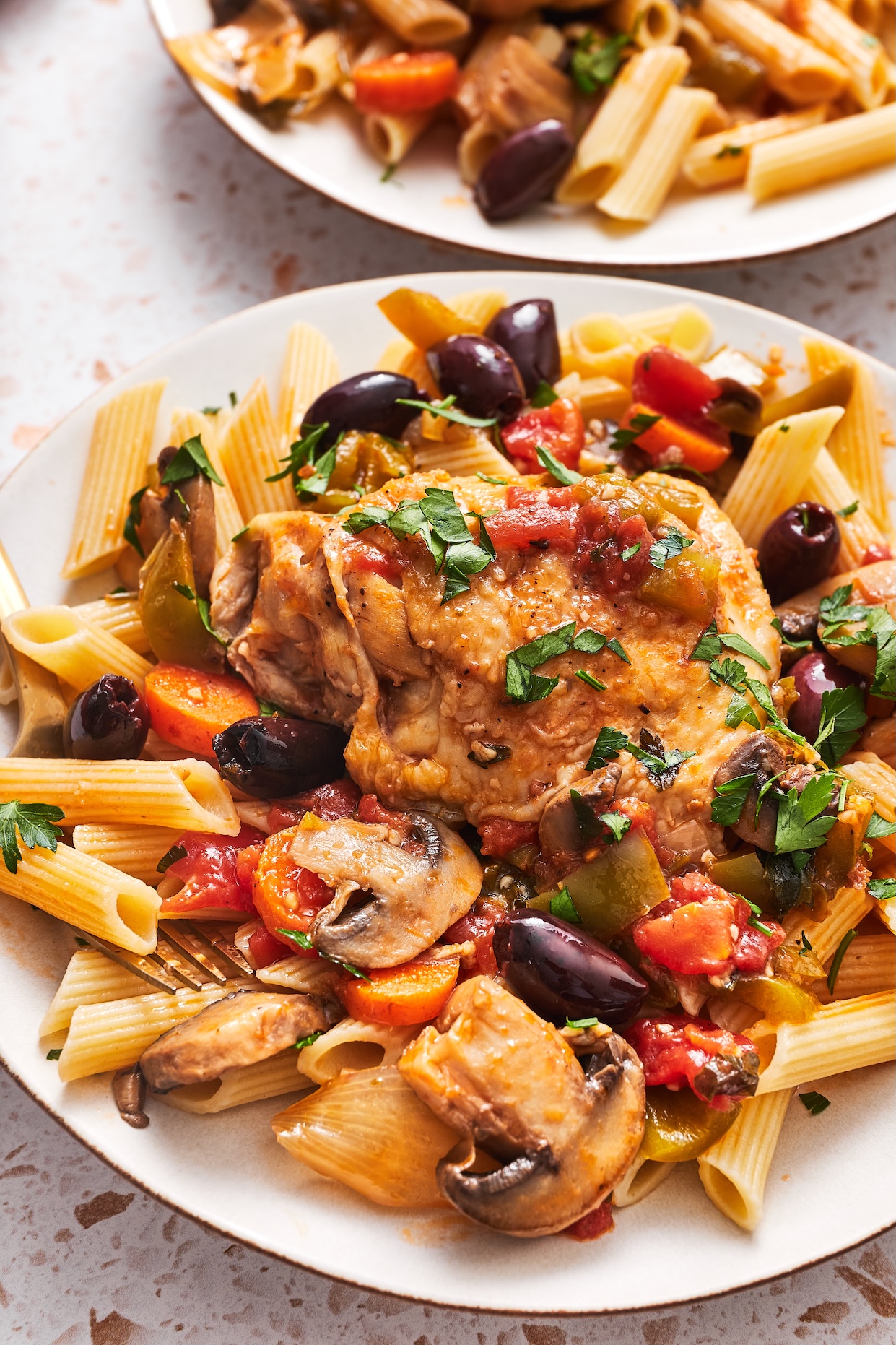 Close up of Instant Pot chicken cacciatore on a plate over cooked pasta