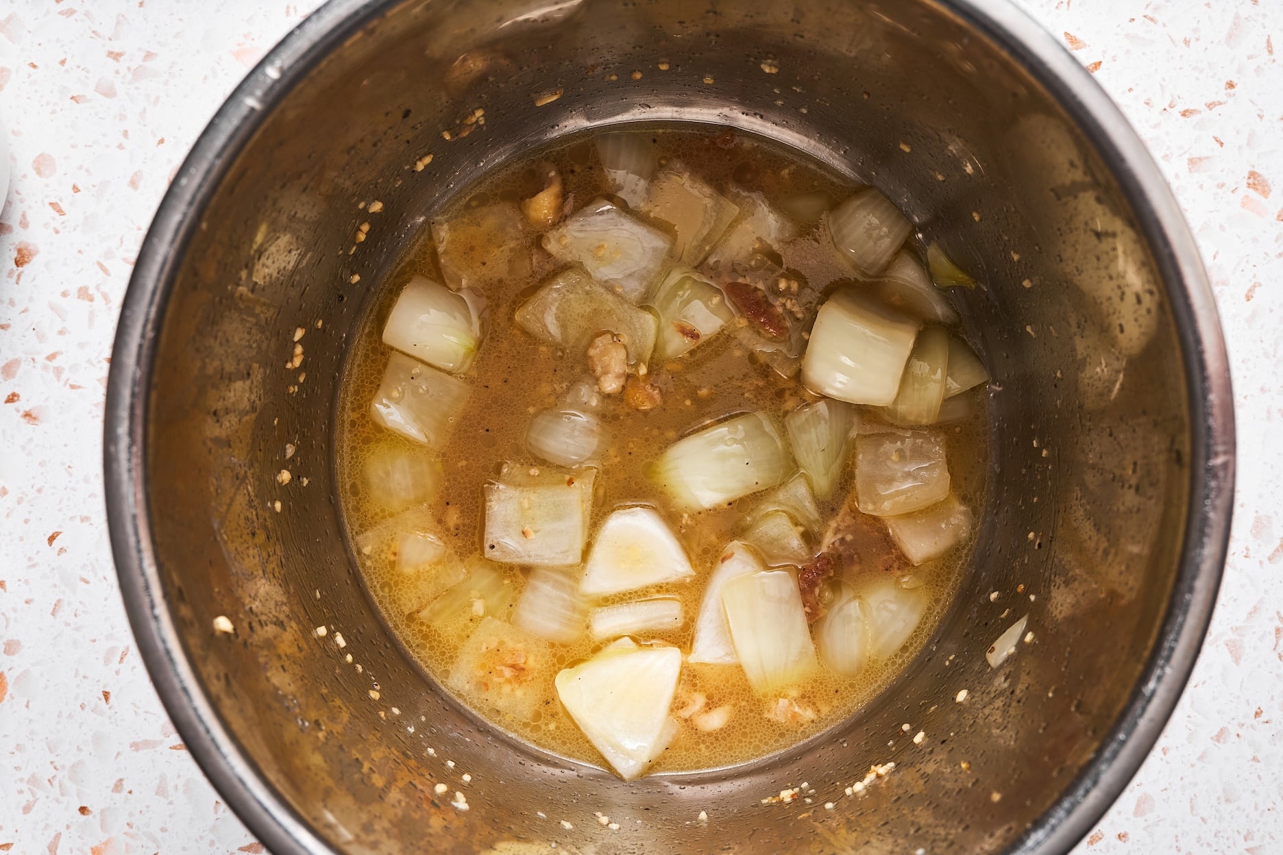 Cooked onion and garlic with broth in the Instant Pot.