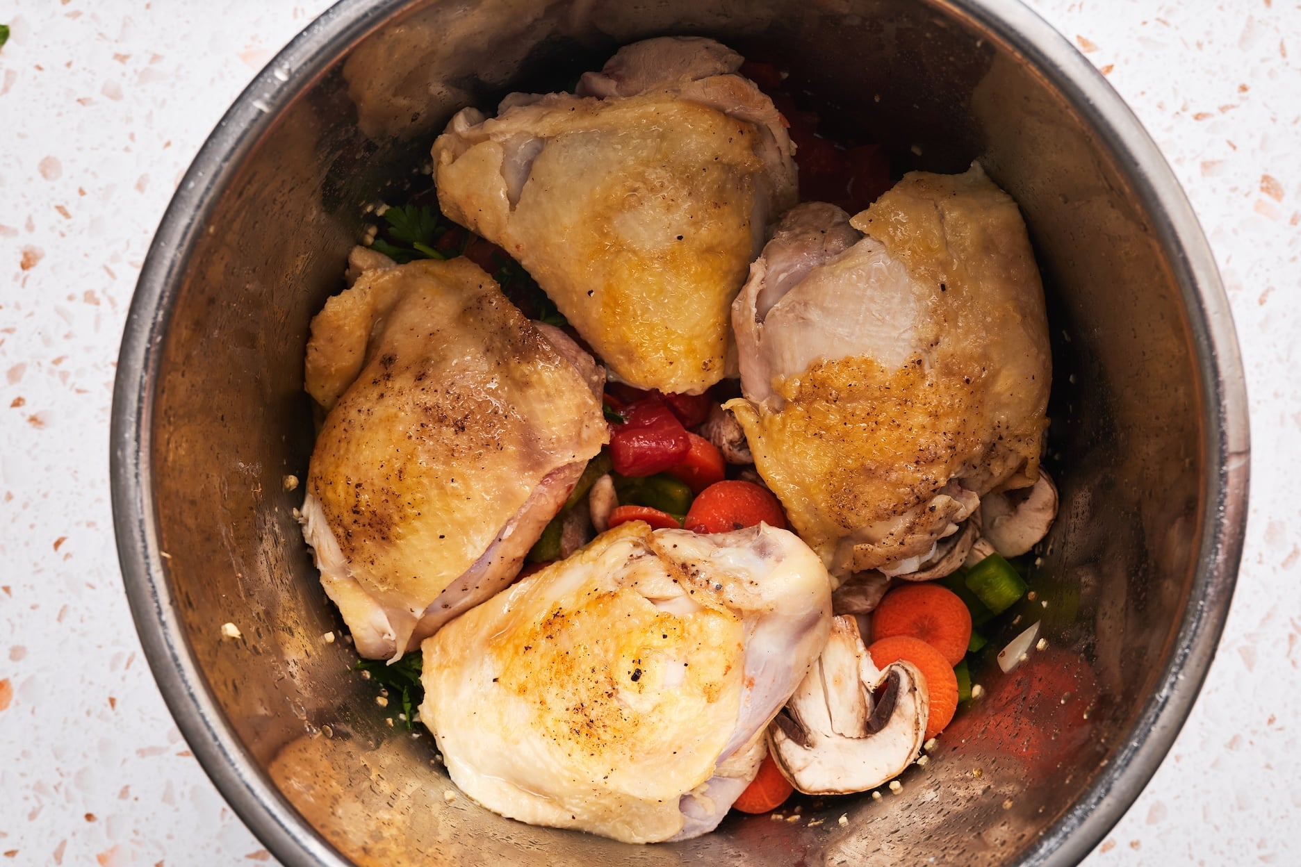 Seared chicken on top of vegges in the Instant Pot.