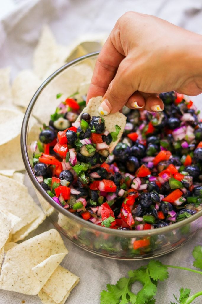 tortilla chip dipped in blueberry salsa