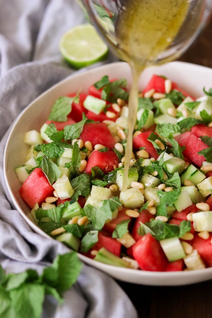 pouring dressing over watermelon salad recipe