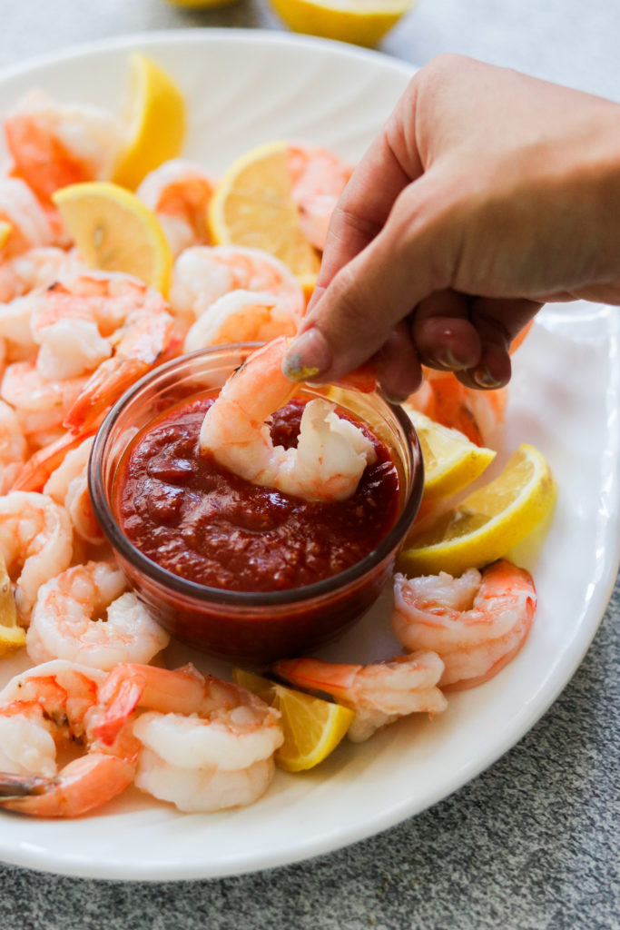 Dipping Instant Pot Shrimp Cocktail in cocktail sauce