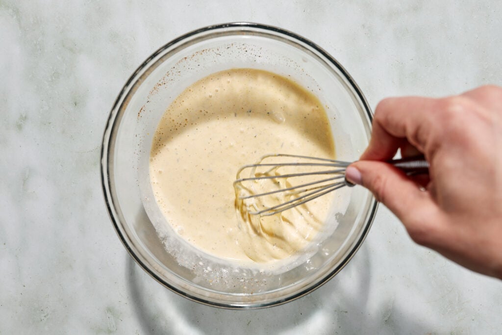 Whisking together creamy dressing in a bowl