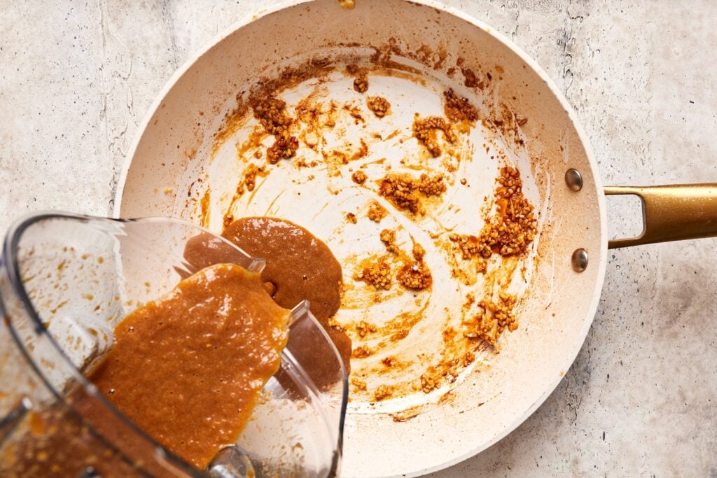 adding teriyaki sauce to the pan with cooked garlic