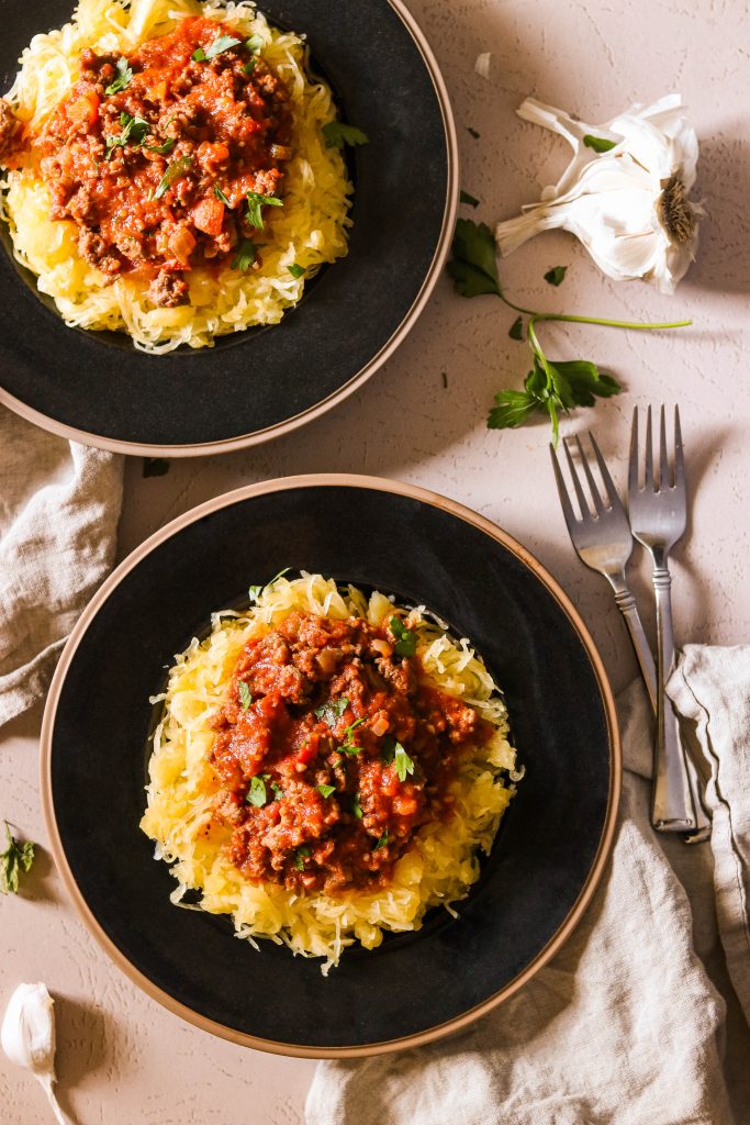 Whole30 meat sauce recipe served on 2 plates over spaghetti squash