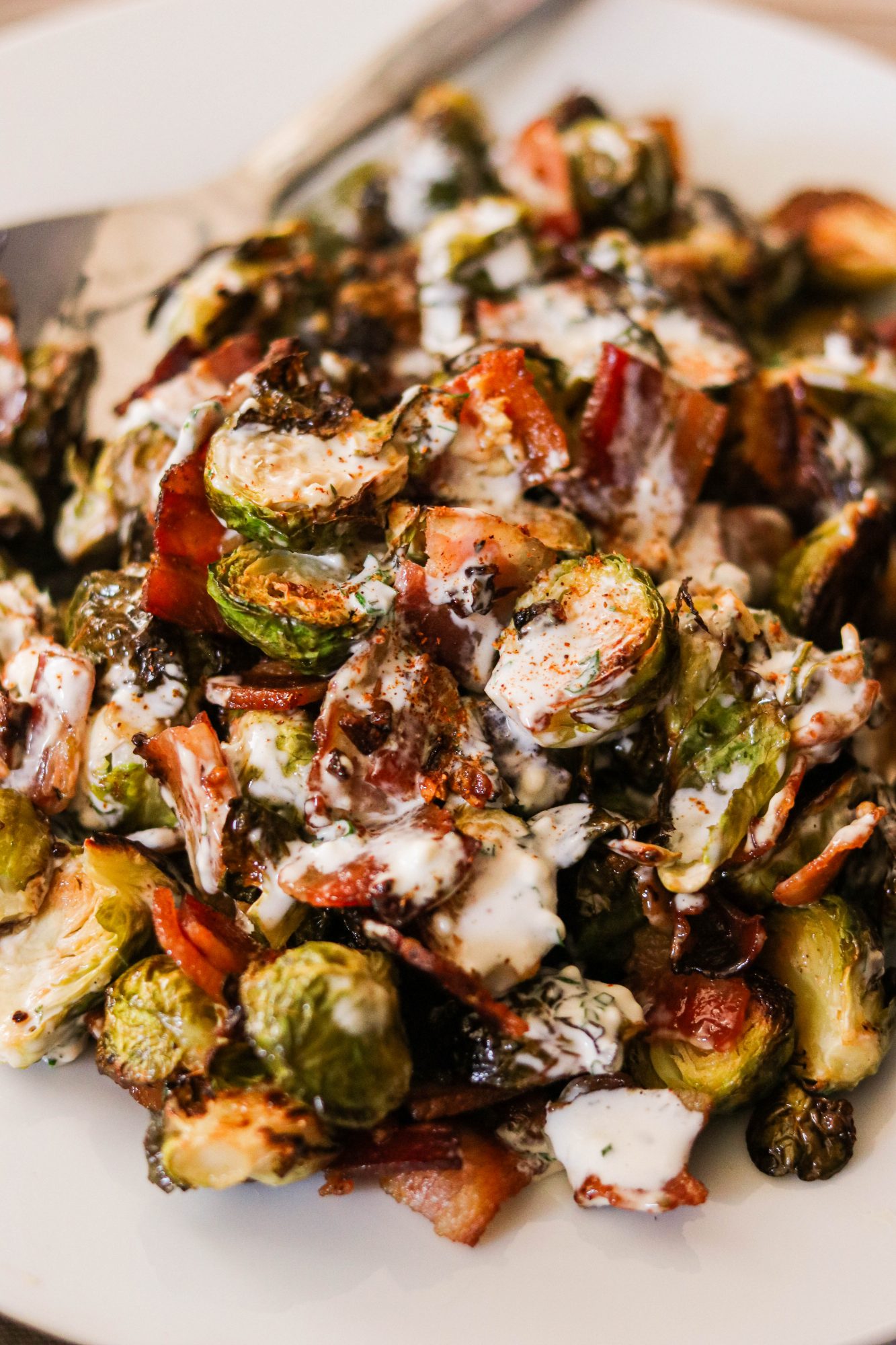 close up shot of keto brussels sprouts topped with bacon and ranch