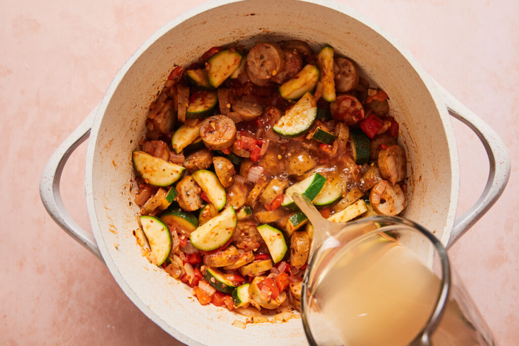 pouring the broth into the soup pot