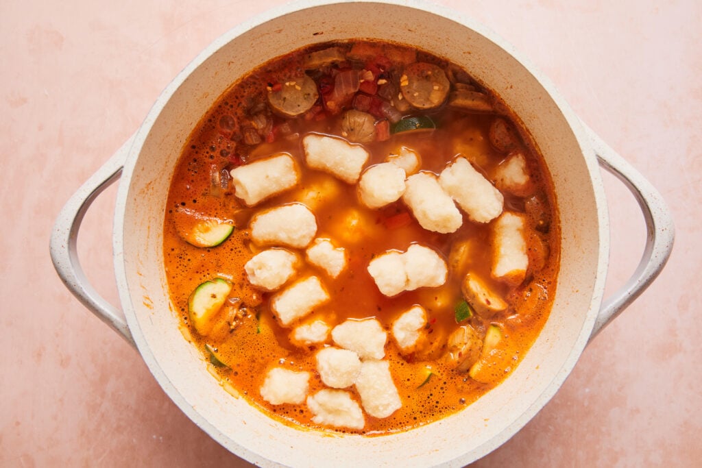 adding the gnocchi into the pot to cook