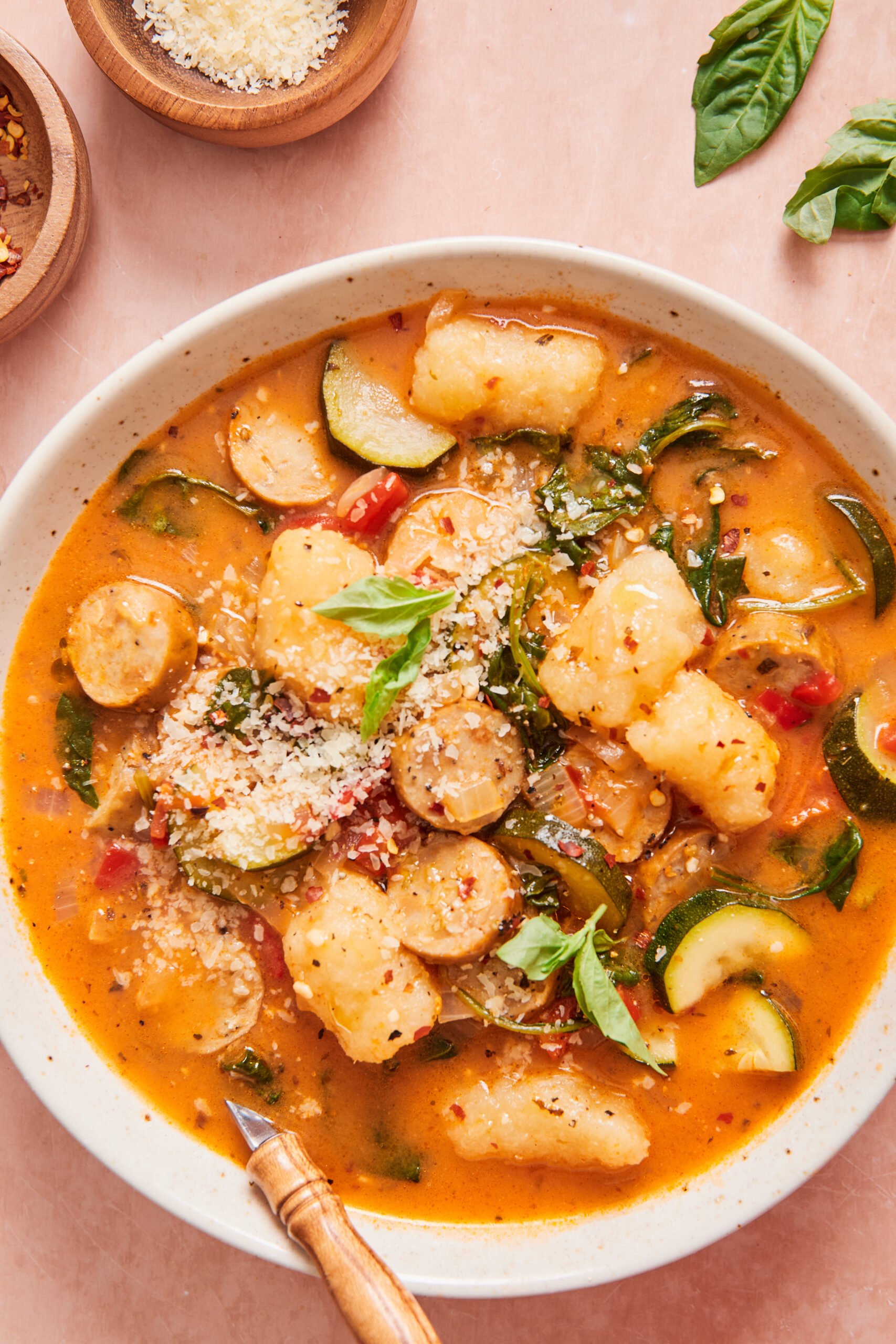 italian sausage and gnocchi soup in a white bowl with a spoon