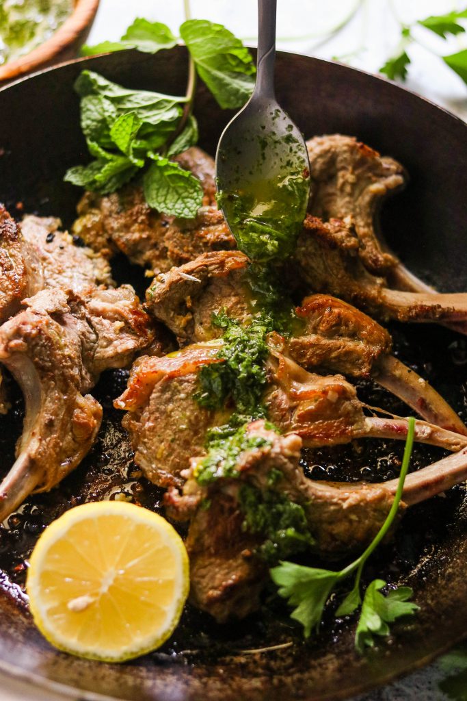 whole30 lamb chops, getting mint chimichurri sauce over it with a spoon