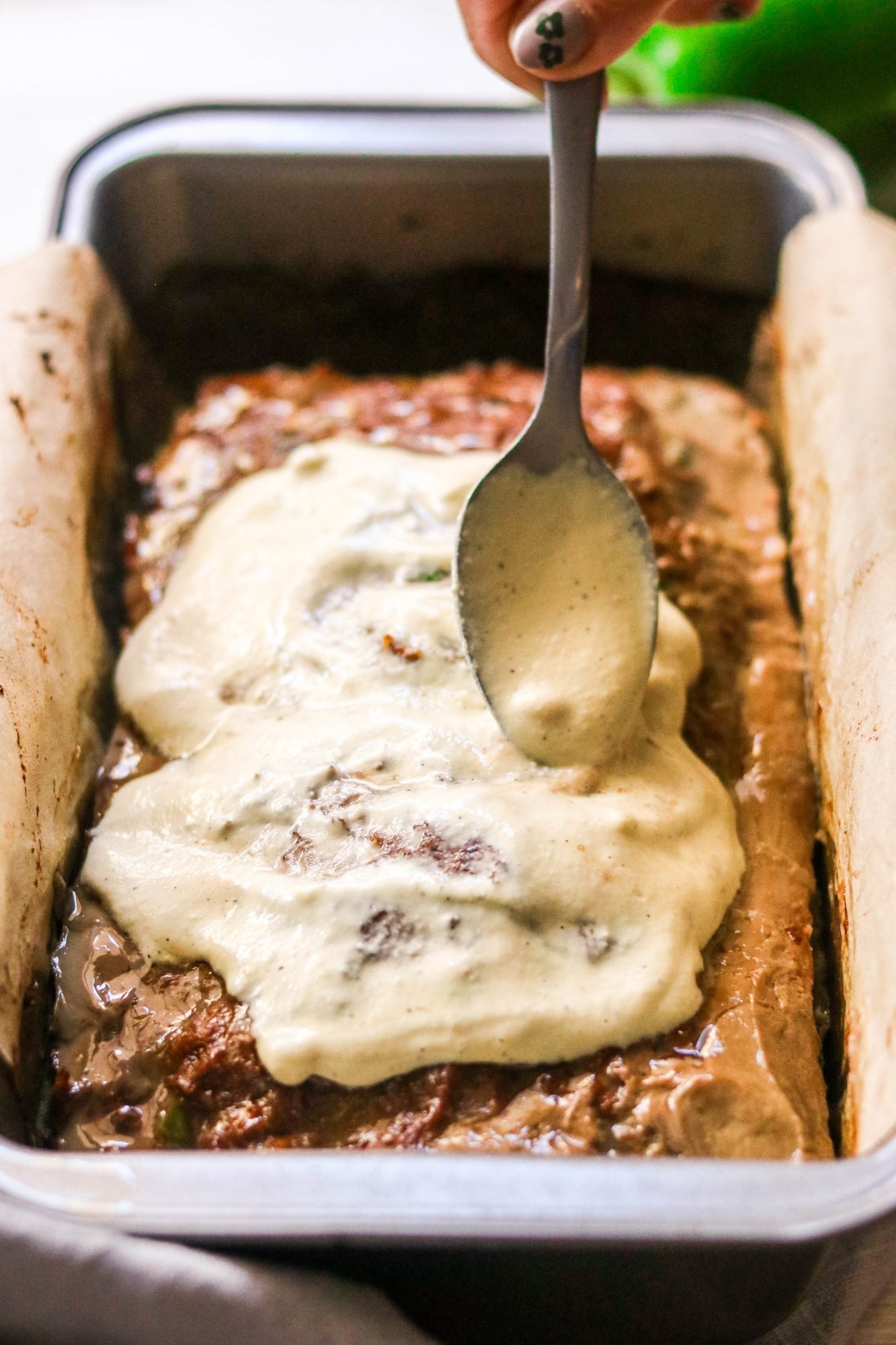 philly cheesesteak meatloaf spooned with cashew cheese sauce