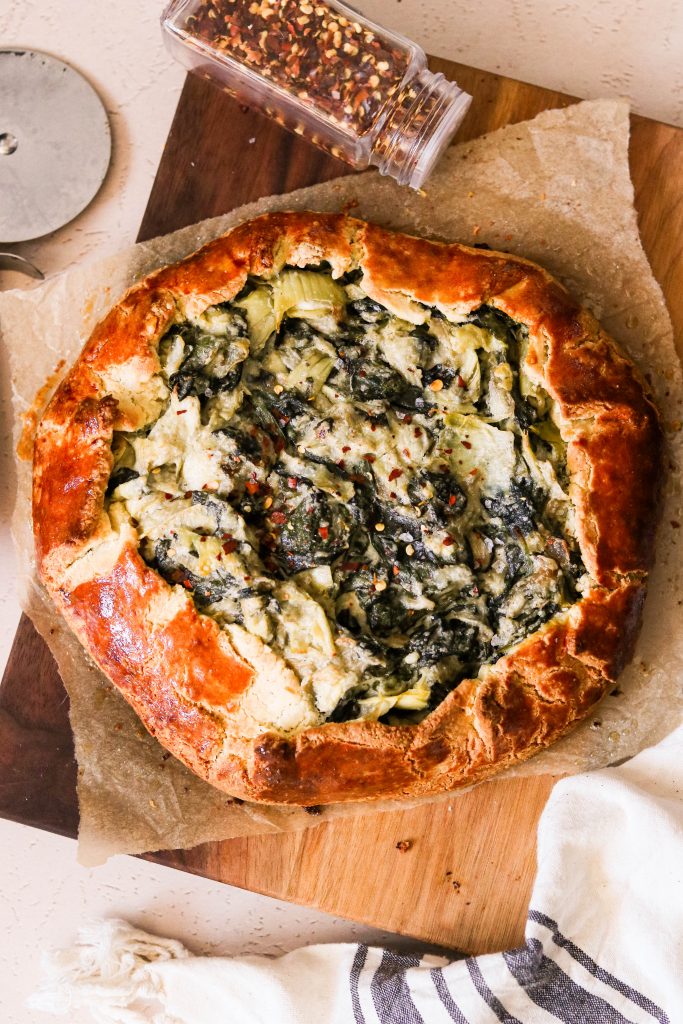 paleo spinach and artichoke galette fresh out of the oven on top of parchment paper