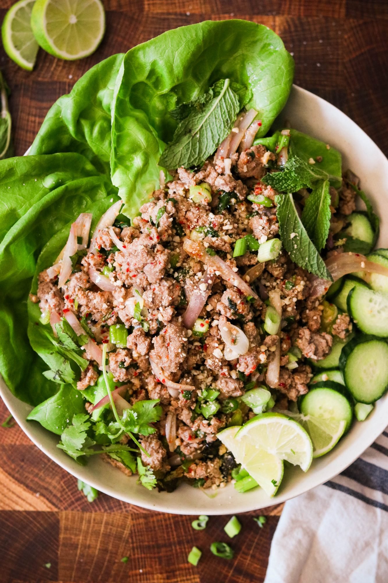 thai larb recipe served on plate with lettuce and cucumbers