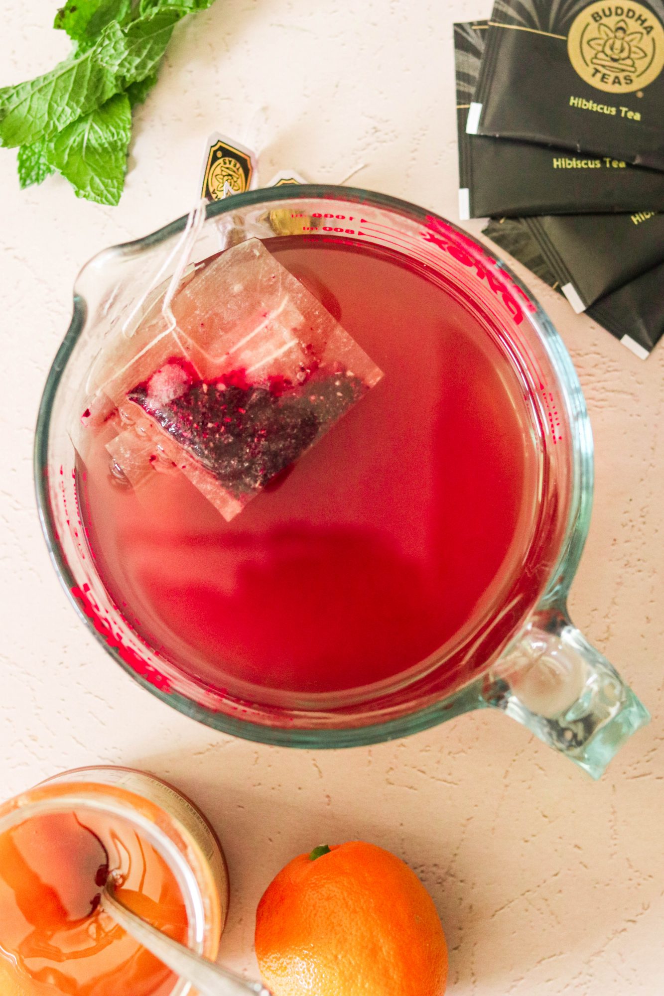 steeping hibiscus tea in a glass measuring cup
