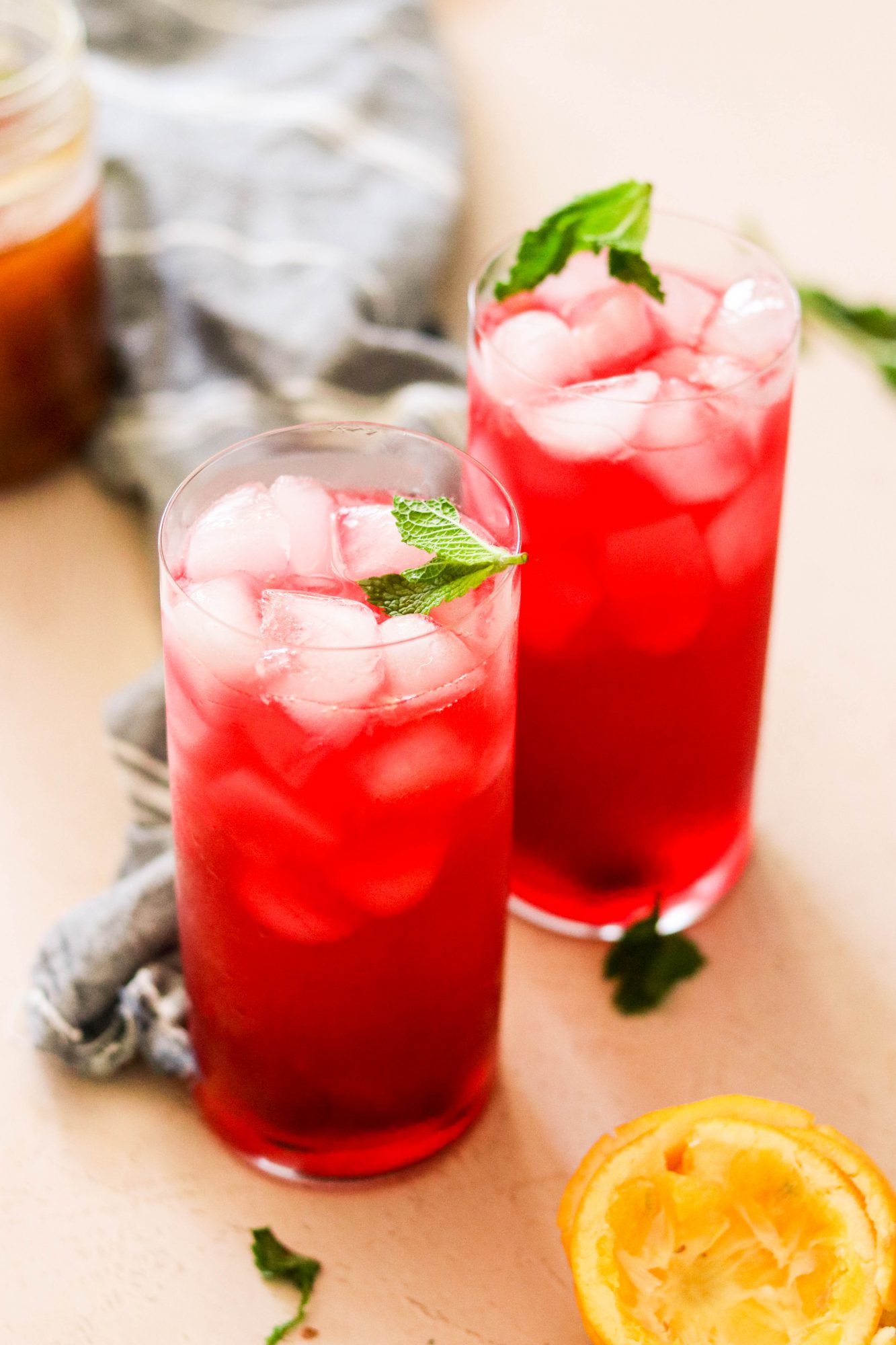 homemade lemonade with honey and hibiscus poured into glasses garnished with mint leaves