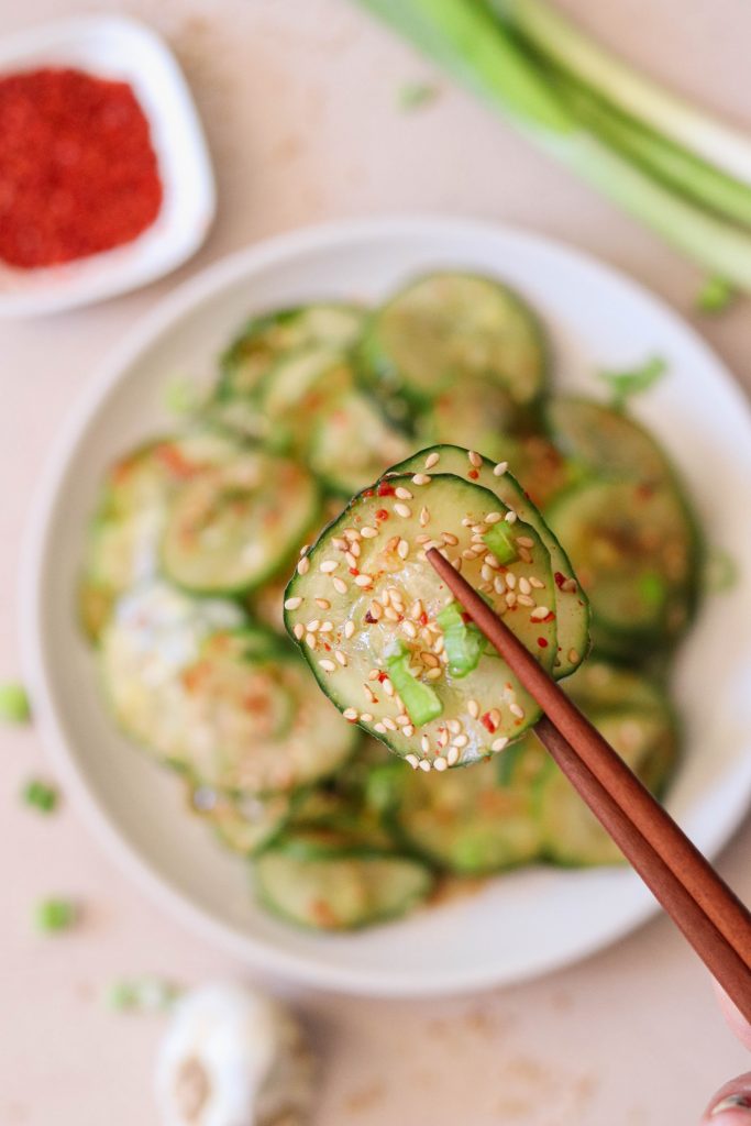 2 slices of cucumber held up with chopsticks.