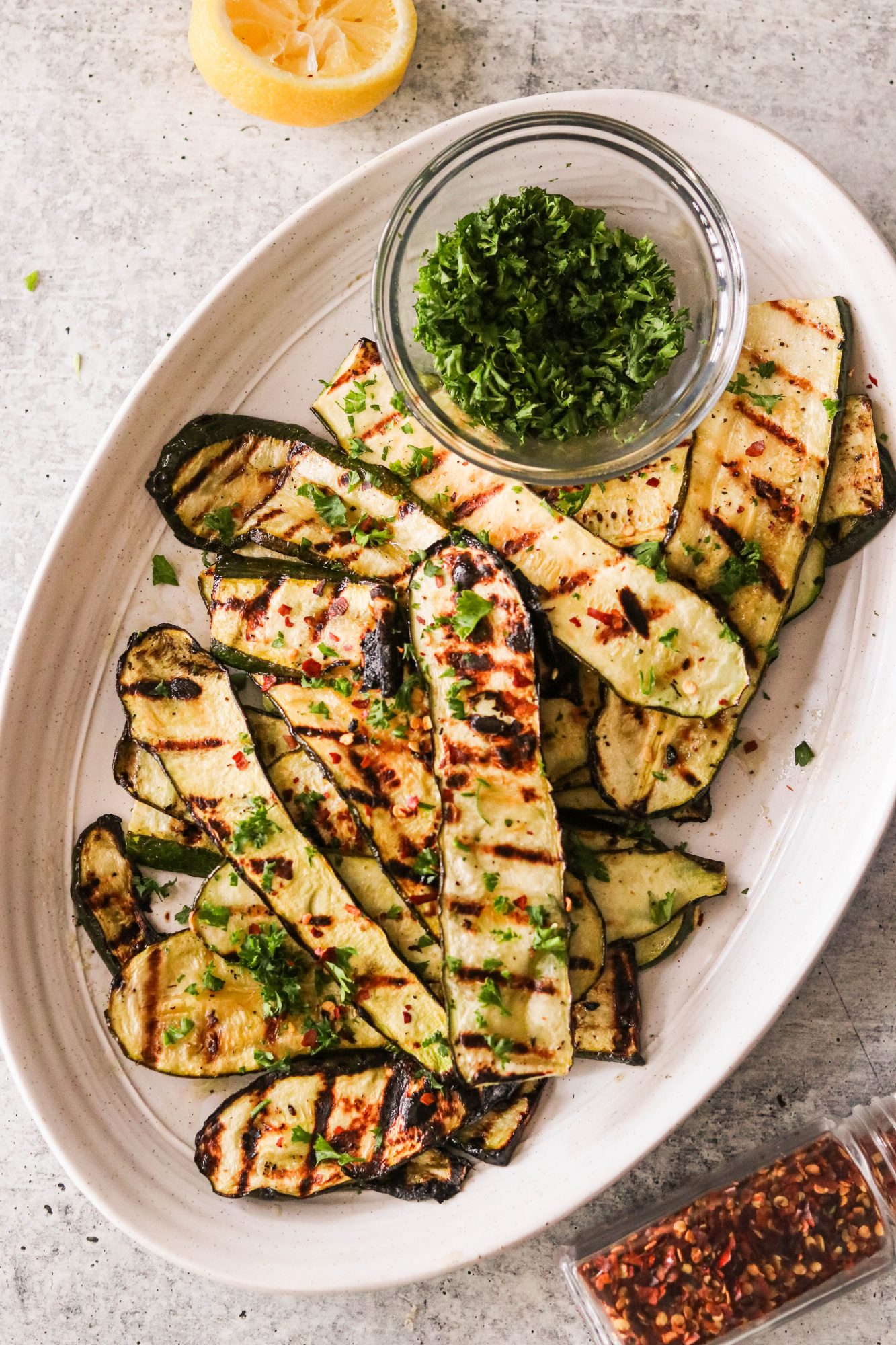 grilled sliced zucchini on a platter topped with parsley