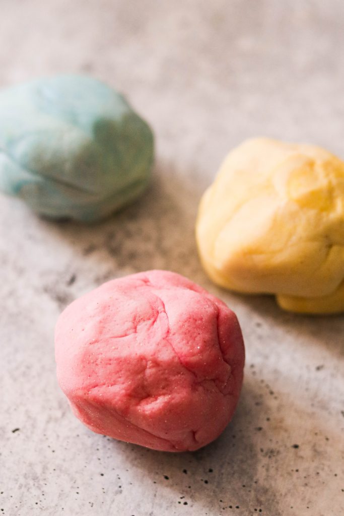 3 balls of homemade playdough in red, yellow, and blue
