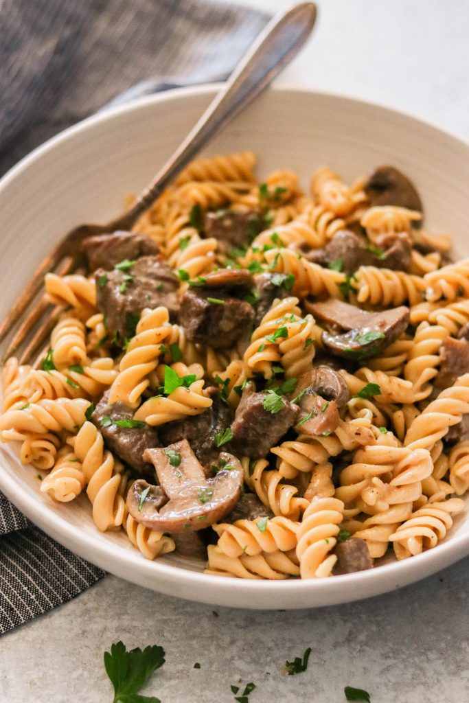beef and mushroom pasta in a bowl with creamy sauce