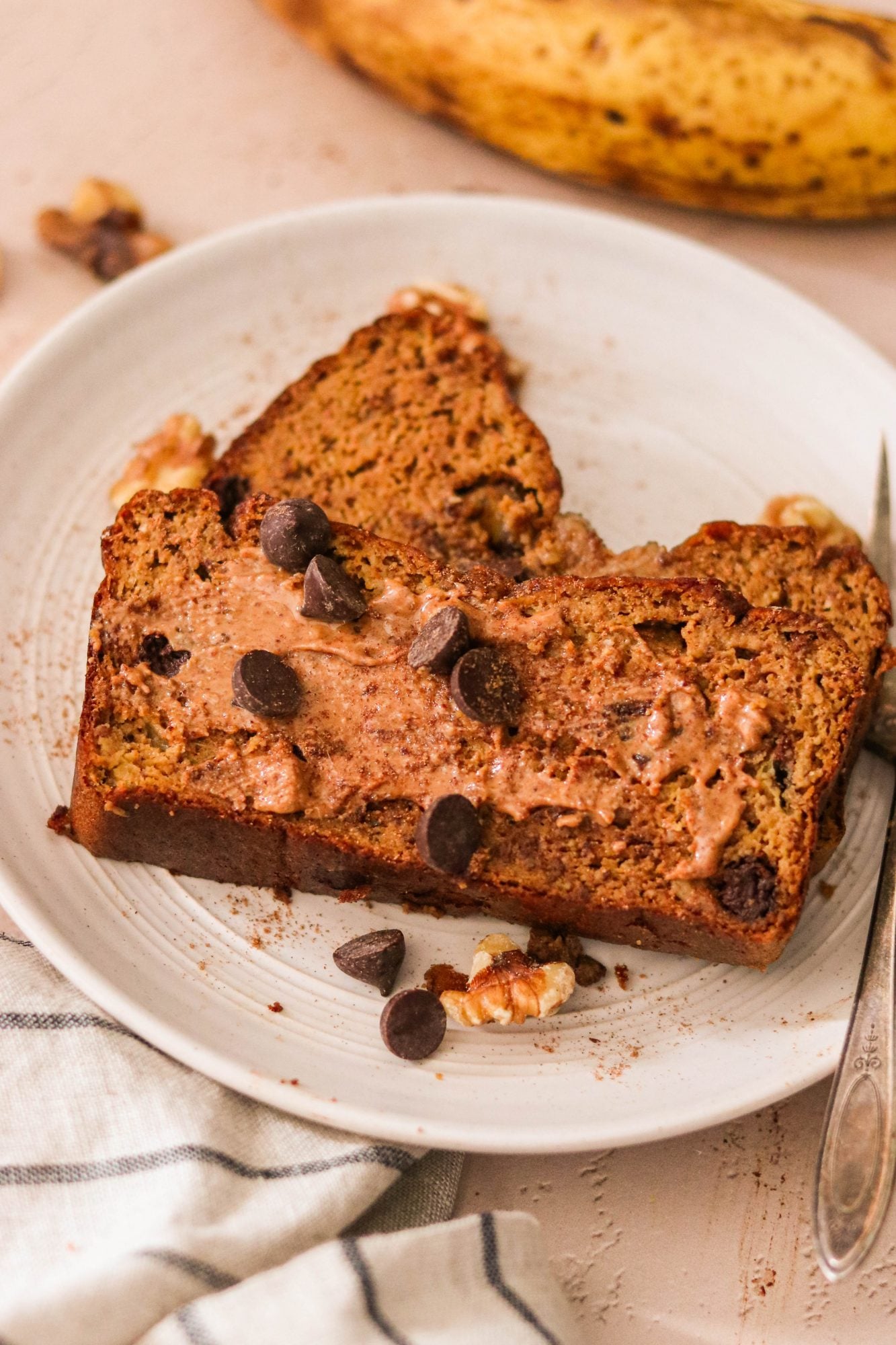 2 slices of banana bread topped with almond butter and chocolate chips