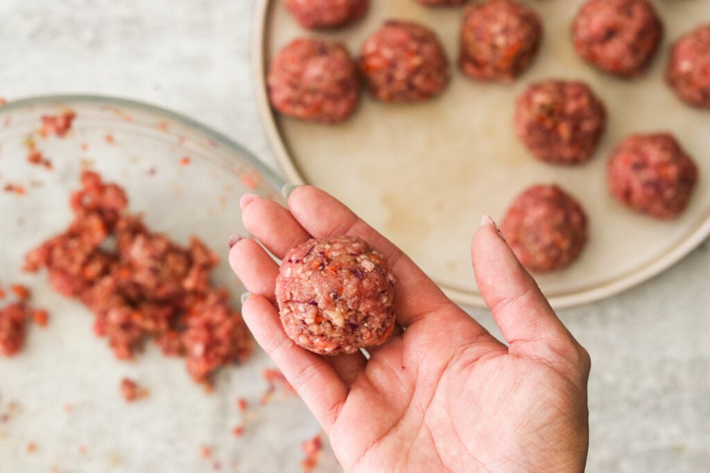 Rolling meatballs with hands.
