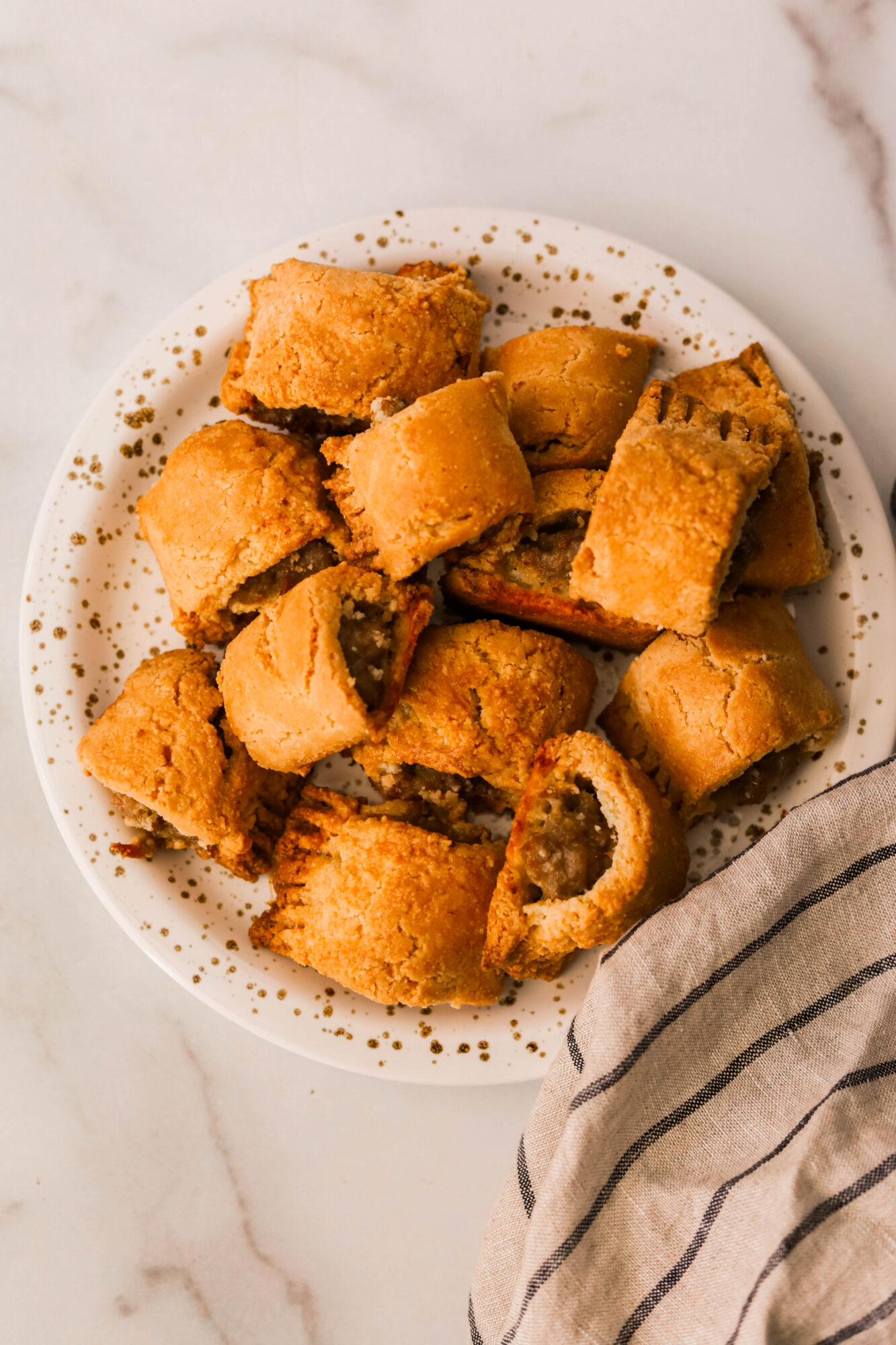 sausage rolls on a white speckled plate