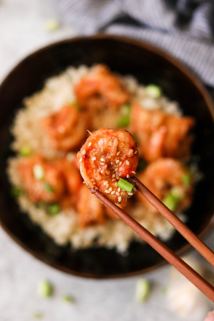 Lifting a shrimp in garlic chili sauce with chopsticks