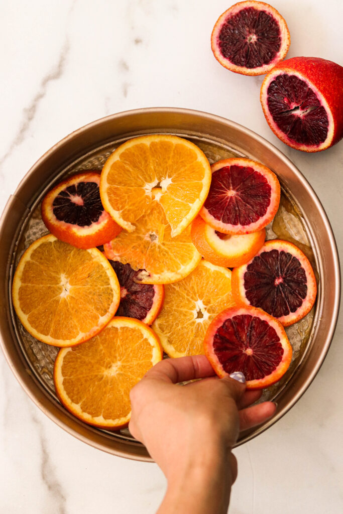 Adding orange slices to a springform pan