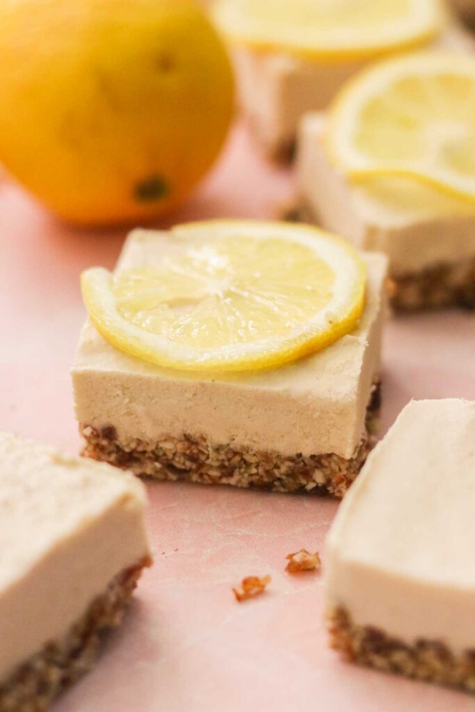 vegan lemon cheesecake bar topped with a slice of lemon