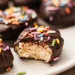 an up close shot of dairy free easter eggs with a bite taken out to show the vegan creme center.