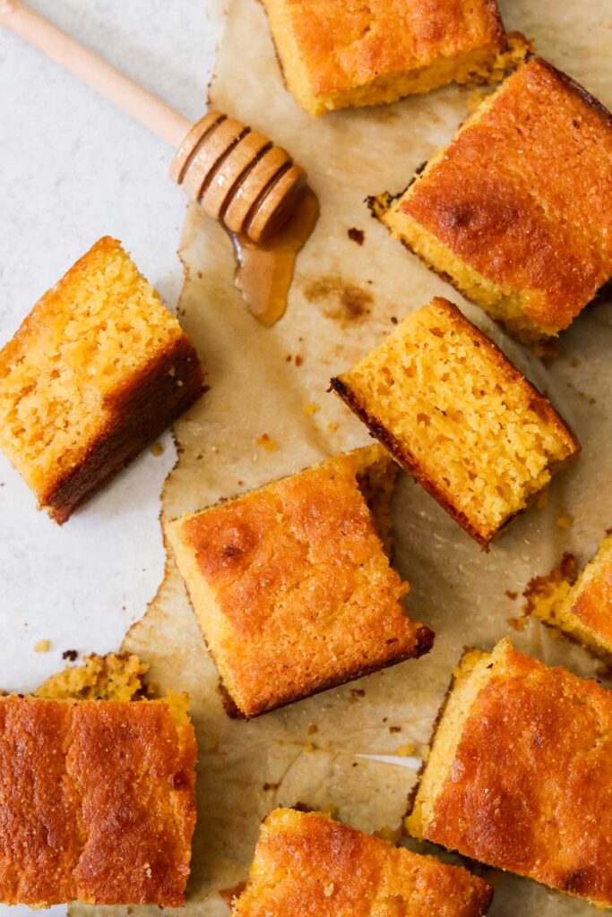 Sliced baked cornbread on parchment paper