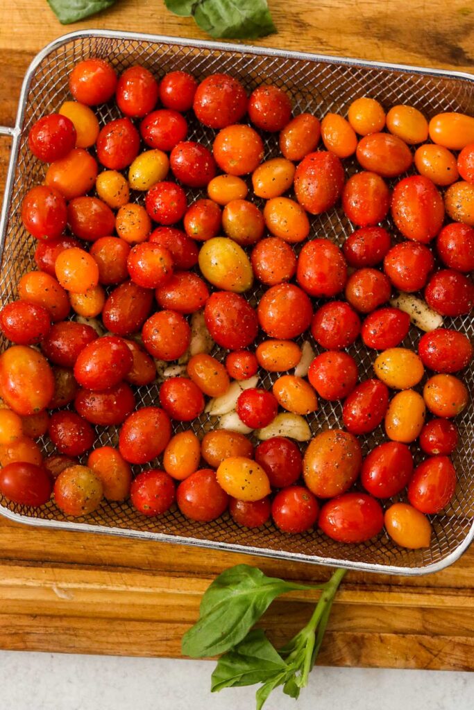 Seasoned cherry tomatoes in an air fryer tray