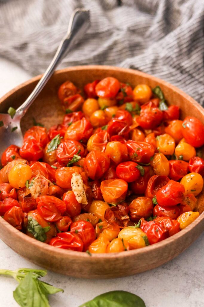 Garlic roasted tomatoes in a bowl with a spoon