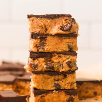 A stack of chocolate peanut butter bars on parchment paper