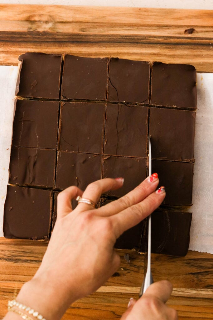 Slicing no bake chocolate peanut butter bars into squares