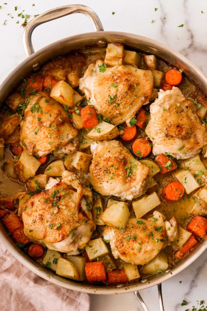 Whole30 chicken thighs with potatoes and carrots in a pan