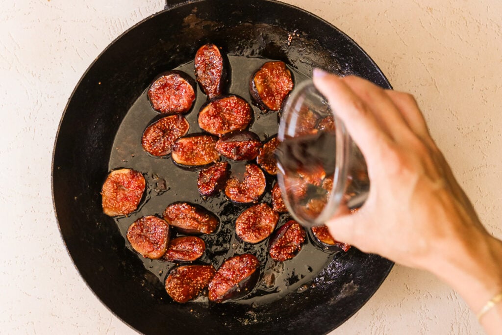 Pouring balsamic vinegar over caramelized figs