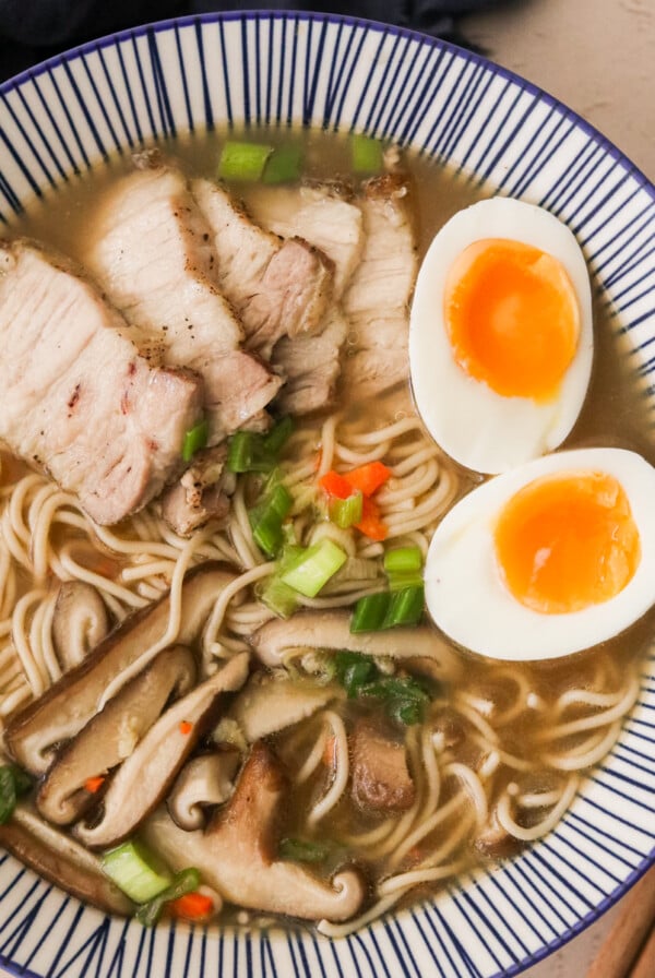 an overhead shot of a bowl of gluten free ramen topped with eggs and pork.
